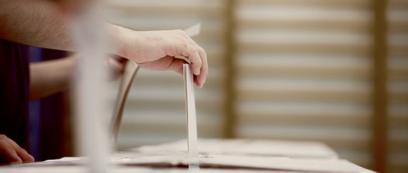 Voter using ballot box
